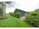 Spacious backyard with lush green grass, mature trees, and screened lanai at 23493 Taber Ave, Port Charlotte, FL 33954