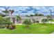 Well-kept single-story home featuring manicured landscaping, a two-car garage, and an American flag at 23493 Taber Ave, Port Charlotte, FL 33954