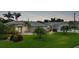 Exterior dusk shot of home featuring lush landscaping, flag pole, and decorative front door at 23493 Taber Ave, Port Charlotte, FL 33954