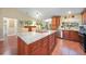 Large kitchen island with wooden cabinets and light countertops, stainless steel appliances, and hardwood floors at 23493 Taber Ave, Port Charlotte, FL 33954