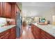 Open kitchen with stainless steel appliances, granite countertops, tile backsplash, and hardwood floors at 23493 Taber Ave, Port Charlotte, FL 33954