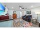 Comfortable living room features light walls, wood-look floors, ceiling fan, and cozy seating at 23493 Taber Ave, Port Charlotte, FL 33954