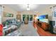Bright and airy living room featuring a sliding glass door, comfortable seating, and wood flooring at 23493 Taber Ave, Port Charlotte, FL 33954
