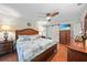 Main bedroom features a barn door, hardwood floors, ceiling fan, and ensuite bathroom with a tiled shower at 23493 Taber Ave, Port Charlotte, FL 33954