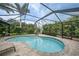 Enjoy the private screened pool surrounded by brick pavers and tropical landscaping at 23493 Taber Ave, Port Charlotte, FL 33954