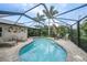 Enjoy the private screened pool surrounded by brick pavers and tropical landscaping at 23493 Taber Ave, Port Charlotte, FL 33954