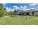 The screened-in pool offers a private oasis with ample green space and mature trees in the expansive backyard at 237 Strasburg Dr, Port Charlotte, FL 33954