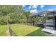 A backyard with a pool inside screened enclosure, lawn, and mature landscaping offers privacy and recreation at 237 Strasburg Dr, Port Charlotte, FL 33954