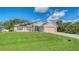 Charming home showcasing manicured lawn, mature trees, solar panels, and attached two car garage at 237 Strasburg Dr, Port Charlotte, FL 33954