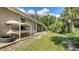 Side of home featuring kayak rack, tropical landscaping, and access to the screened patio and pool at 237 Strasburg Dr, Port Charlotte, FL 33954