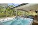 This screened lanai features a luxurious hot tub and seating area, perfect for relaxation at 237 Strasburg Dr, Port Charlotte, FL 33954