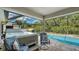 This covered patio offers views of the pool and backyard, as well as lounge seating and a hot tub at 237 Strasburg Dr, Port Charlotte, FL 33954