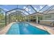 This backyard features a screened-in pool, covered patio, hot tub, and outdoor seating and dining areas at 237 Strasburg Dr, Port Charlotte, FL 33954