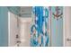 This renovated shower features a white tiled enclosure with an updated shower head and charming nautical accents at 237 Strasburg Dr, Port Charlotte, FL 33954