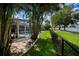 Backyard with a pool, lawn, and waterfront views, framed by palm trees at 2387 Nuremberg Blvd, Punta Gorda, FL 33983