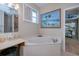 Bathroom featuring a garden tub beneath a window, complemented by beach-themed artwork at 2387 Nuremberg Blvd, Punta Gorda, FL 33983