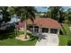 Aerial view of the home with a tile roof, an American flag, and a well-manicured lawn at 2387 Nuremberg Blvd, Punta Gorda, FL 33983
