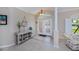 Inviting foyer with tile flooring, decorative console table, and glass-paneled double doors, offering a warm welcome at 2387 Nuremberg Blvd, Punta Gorda, FL 33983
