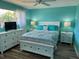 This bedroom features a white bed and dressers with a view to the exterior at 26129 Madras Ct, Punta Gorda, FL 33983