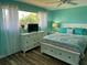 This bedroom features a white bed and dressers with a view to the exterior at 26129 Madras Ct, Punta Gorda, FL 33983