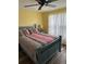 Bedroom with yellow walls, dark trim, bed, ceiling fan, and natural light at 26129 Madras Ct, Punta Gorda, FL 33983