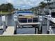 View of boat docked on a canal with tropical landscaping and neighborhood in the background at 311 Garvin St # 405B, Punta Gorda, FL 33950