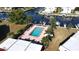 Aerial view of a community pool surrounded by palm trees, lush landscaping, and canal access at 311 Garvin St # 405B, Punta Gorda, FL 33950