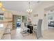 Dining area with elegant table and chairs, modern light fixture, and sliding glass doors to the patio at 3138 Darius Ave, North Port, FL 34288
