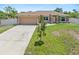 Inviting single-story home with a well-manicured lawn, a two-car garage, and mature landscaping at 3138 Darius Ave, North Port, FL 34288