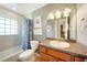 Inviting bathroom with tiled tub, vanity and mirror with decorative lighting at 3171 Highlands Rd, Punta Gorda, FL 33983