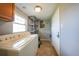 Practical laundry room with modern machines, storage shelving, and backyard access door at 3171 Highlands Rd, Punta Gorda, FL 33983