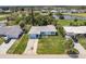 Aerial view of a light blue single-story home with a large green lawn and mature landscaping near a pond at 37 Oakland Hills Ct, Rotonda West, FL 33947