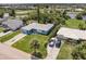 Aerial view of a blue single-Gathering home with a lush lawn, mature trees, and a nearby waterway at 37 Oakland Hills Ct, Rotonda West, FL 33947