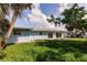 Spacious backyard showcasing lush green grass and exterior of house with many windows at 37 Oakland Hills Ct, Rotonda West, FL 33947