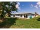 Spacious backyard showcasing lush green grass and exterior of house with several sliding glass doors at 37 Oakland Hills Ct, Rotonda West, FL 33947
