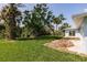 Exterior house with backyard and luscious landscaping with ample foliage and grass at 37 Oakland Hills Ct, Rotonda West, FL 33947