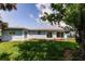 Backyard showcasing lush green grass and exterior of house with many windows at 37 Oakland Hills Ct, Rotonda West, FL 33947