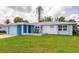 Charming single-story home showcasing a light blue and white exterior, green lawn, and attached garage at 37 Oakland Hills Ct, Rotonda West, FL 33947