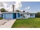 Inviting single-story home with a blue garage door, white accents, and a well-maintained front lawn at 37 Oakland Hills Ct, Rotonda West, FL 33947