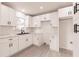 Modern kitchen features white cabinets, black hardware, stainless steel sink, and wood-look floors at 37 Oakland Hills Ct, Rotonda West, FL 33947