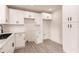 New kitchen with white cabinetry, stainless sink, contrasting black hardware and white subway tile backsplash at 37 Oakland Hills Ct, Rotonda West, FL 33947