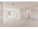 Expansive living room features light wood-look flooring, neutral walls, and sliding glass doors to the outdoors at 37 Oakland Hills Ct, Rotonda West, FL 33947