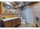 Bathroom with stone tile, wood cabinets and trim, and a large mirror creating a rustic and elegant space at 411 Scarlet Sage, Punta Gorda, FL 33955