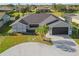 Front exterior features a circular driveway, palm trees, and an attached garage at 411 Scarlet Sage, Punta Gorda, FL 33955