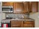 Close up of the kitchenette includes the sink, stove, microwave, and dark wooden cabinets at 411 Scarlet Sage, Punta Gorda, FL 33955