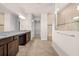 Bright bathroom featuring a dual sink vanity, granite counters and tiled floor and shower at 42346 Waterfront Way, Punta Gorda, FL 33982
