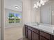 Bathroom featuring a single sink vanity with granite counters, tiled floors and window to view at 42346 Waterfront Way, Punta Gorda, FL 33982
