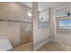 Walk-in shower with tile surround and glass door, adjoining a large bedroom with a view at 42346 Waterfront Way, Punta Gorda, FL 33982