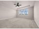 Spacious bedroom with neutral carpet, tray ceiling, fan and large window at 42346 Waterfront Way, Punta Gorda, FL 33982