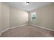A vacant bedroom with neutral walls, plush carpet, and a window providing natural light at 42346 Waterfront Way, Punta Gorda, FL 33982
